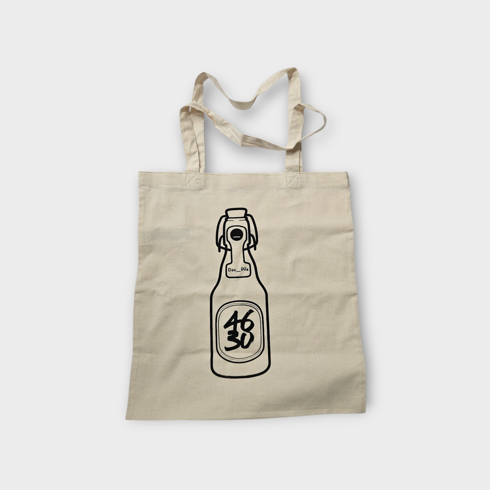 Naturfarbener Stoffbeutel mit schwarzem handgedruckten 4630 Bügelflaschen-Motiv ‚Das_Pils‘.